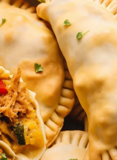 Baked chicken empanadas filled with seasoned chicken, onions, and peppers.