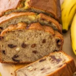 Moist and delicious easy to make banana loaf sliced on parchment paper.