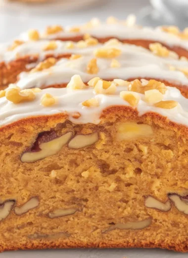 Slice of easy carrot cake loaf topped with cream cheese frosting