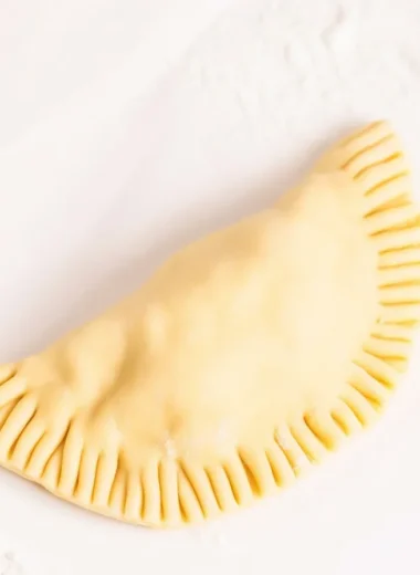 Homemade empanada dough ready for baking or frying, showcasing a flaky texture.