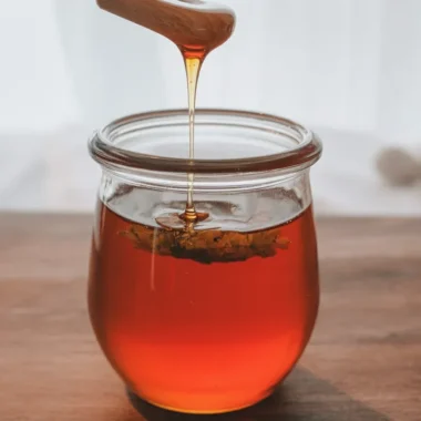 A jar of Hot Honey infused with chilies, perfect for drizzling on various dishes.
