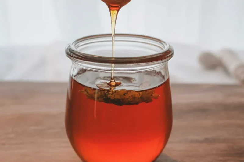A jar of Hot Honey infused with chilies, perfect for drizzling on various dishes.