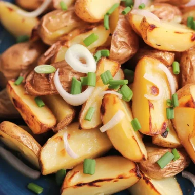 Crispy oven fried potatoes and onions on a baking sheet, golden and delicious.
