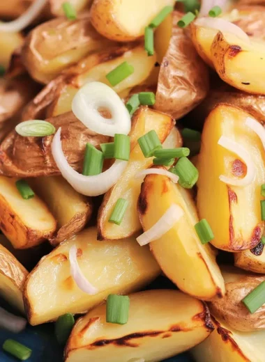 Crispy oven fried potatoes and onions on a baking sheet, golden and delicious.