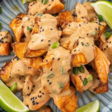 Delicious Bang Bang Salmon topped with creamy sauce and served with rice and avocado salsa.