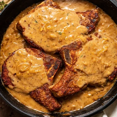 Southern Smothered Pork Chops served with rich onion gravy and mashed potatoes.