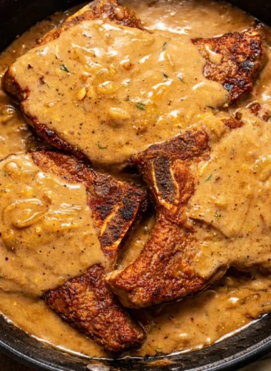Southern Smothered Pork Chops served with rich onion gravy and mashed potatoes.