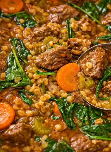 Bowl of hearty beef and barley soup loaded with tender chunks of beef and fresh vegetables.