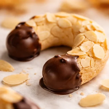 Traditional German Almond Horns (Mandelhörnchen) - chewy almond cookies dipped in chocolate.